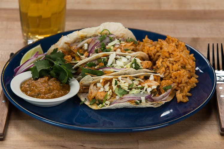 Chipotle chicken tacos in soft flour tortillas with cabbage slaw, salsa and Spanish red rice.