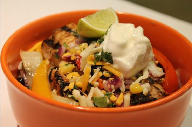 Chicken burrito bowl with rice, corn and black bean relish, cheese and sour cream.
