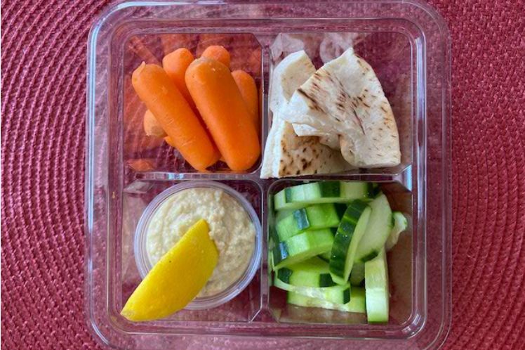 Fresh cut cucumbers and carrots with lemony hummus and pita triangles for dipping.