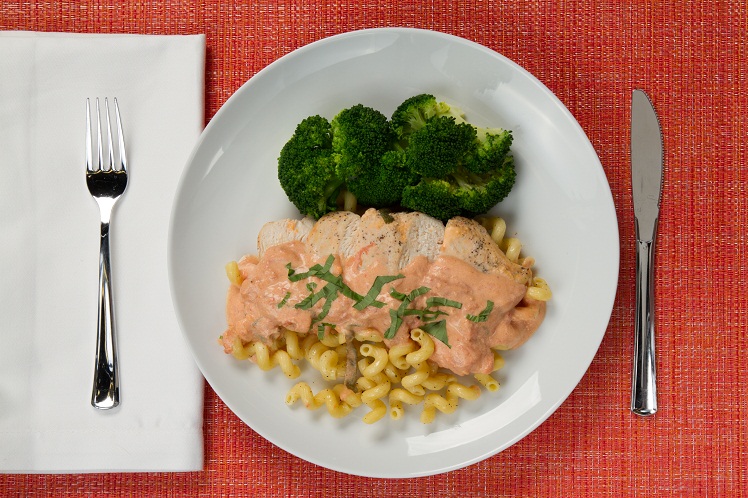 Roasted chicken slices over cavatappi pasta in creamy tomato basil sauce with broccoli.