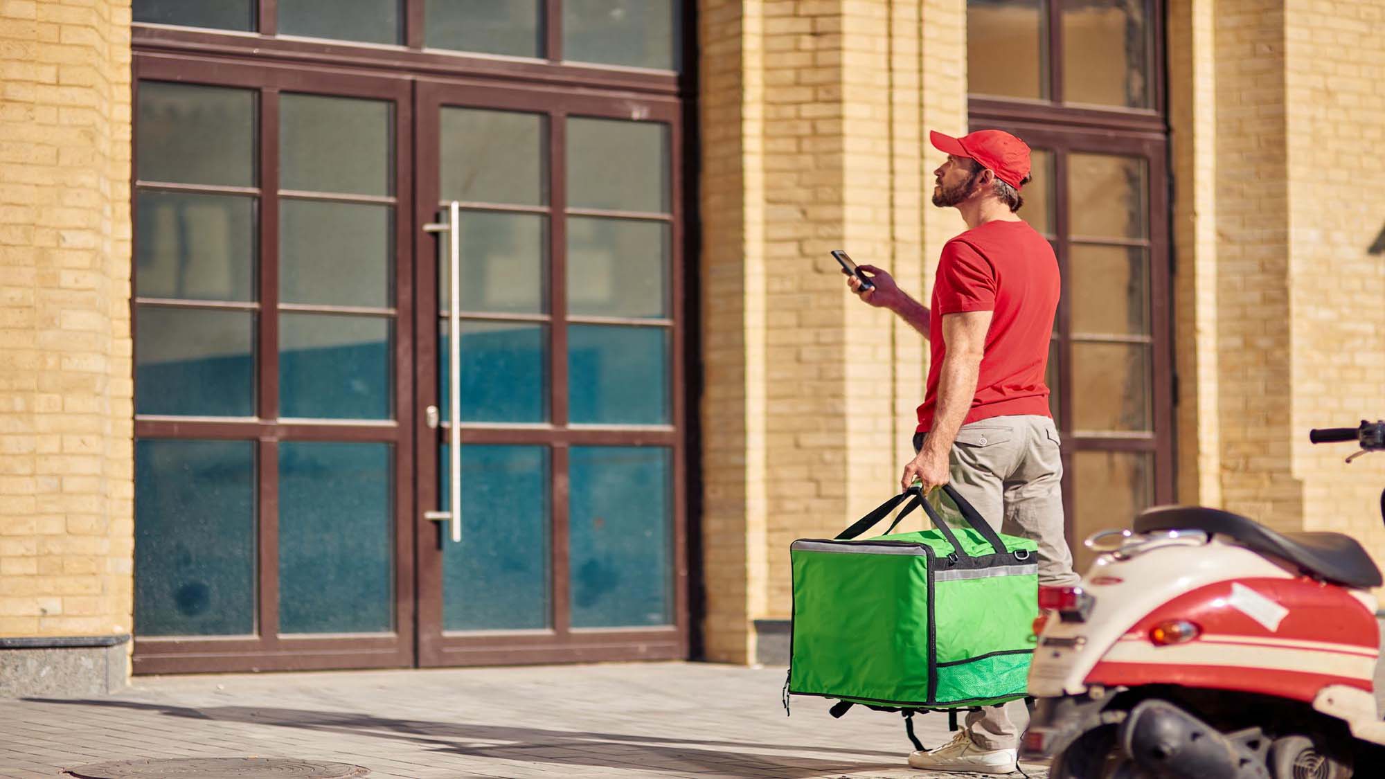 delivery-boy-standing-near-customer-house-for-meal-delivery-services