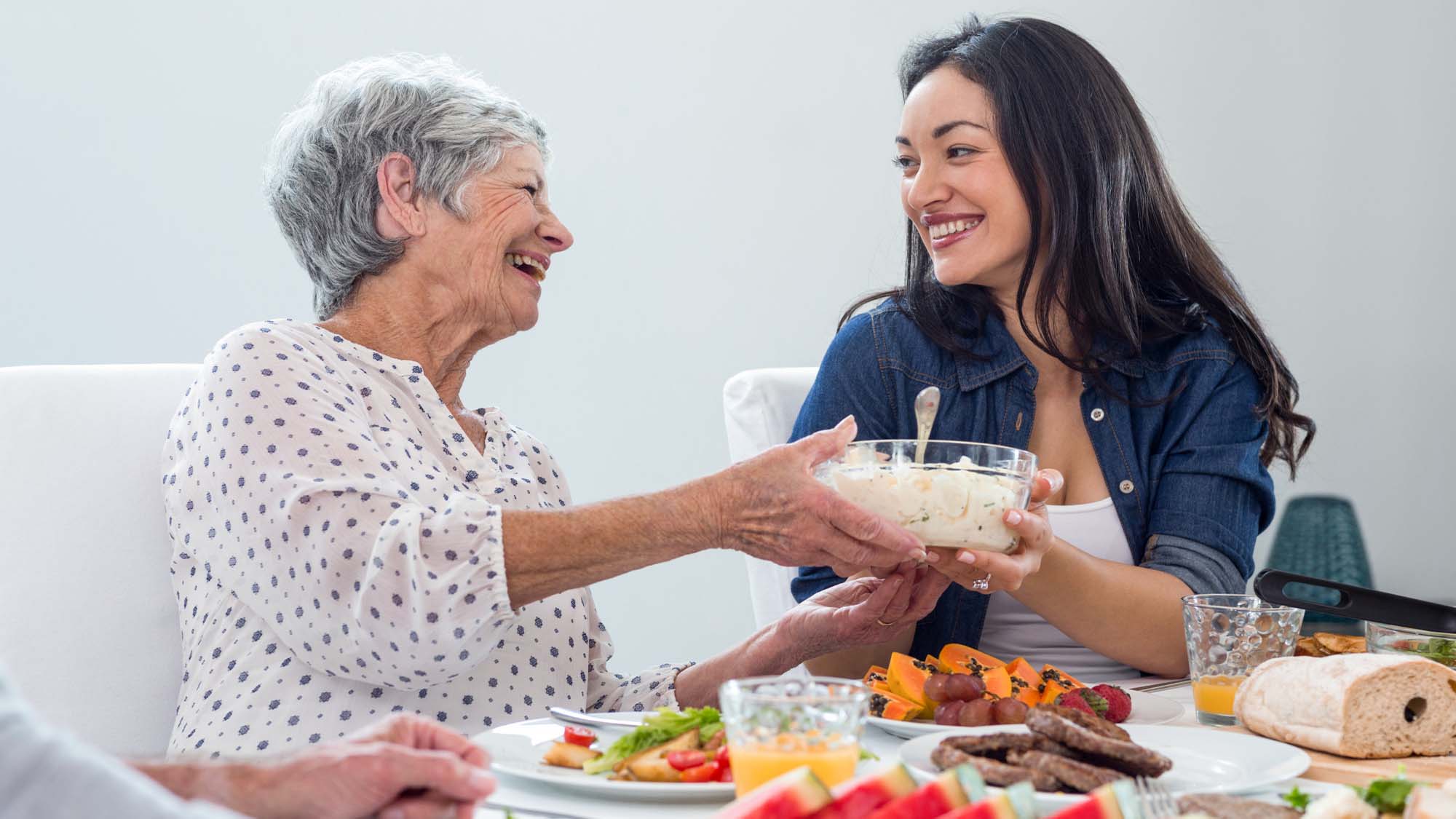 senior-mother-and-young-daughter-enjoying-a-meal-on-mothers-day