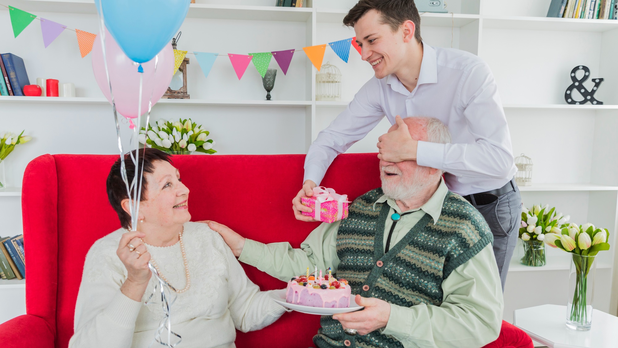 son-giving-gift-to-elderly-parents-on-birthday