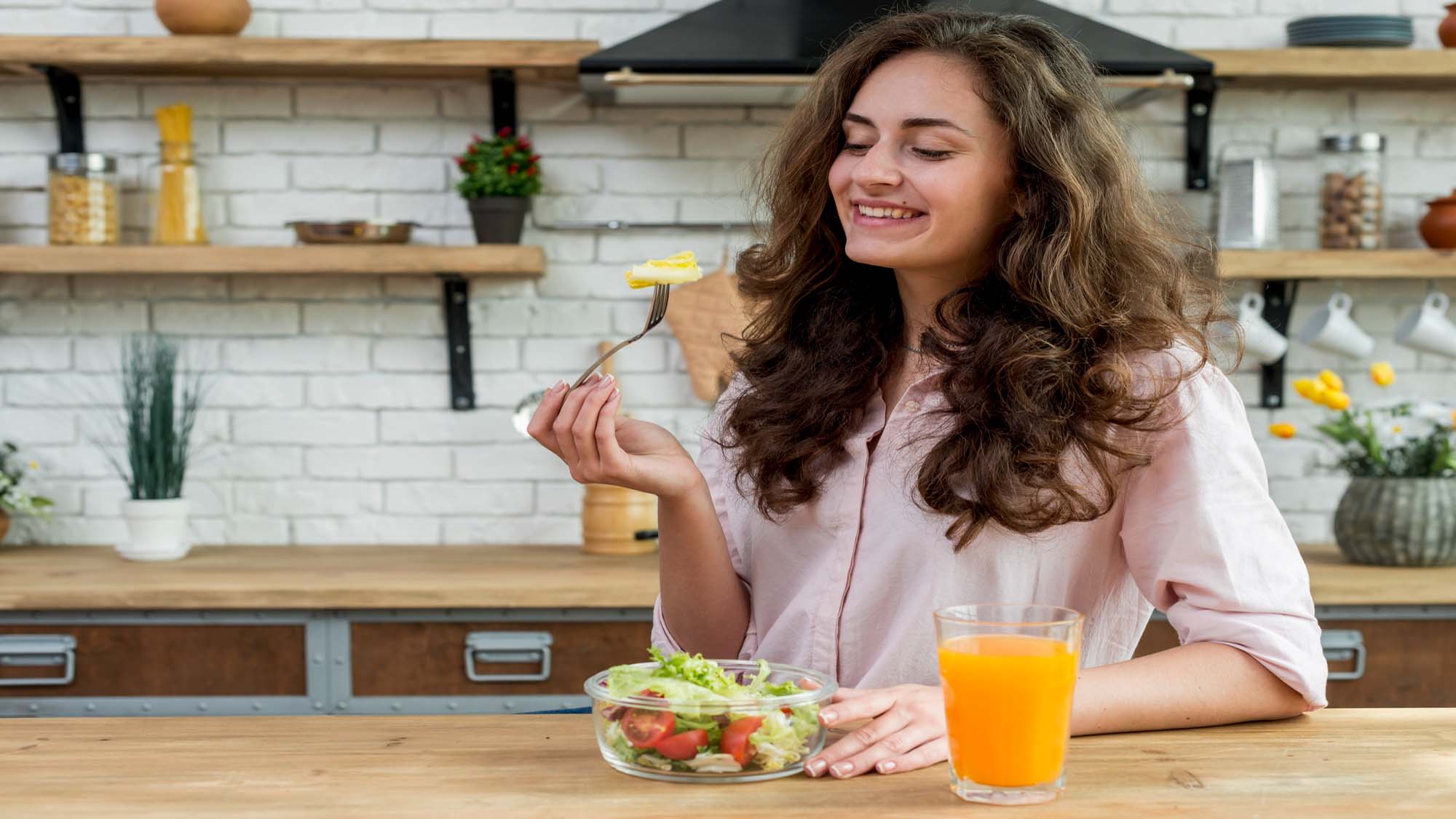 woman-eating-healthy-salad-of-meal-village